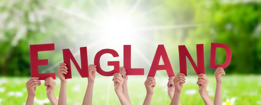 People Or Persons Hands Building English Word England. Sunny Green Grass Meadow As Background.