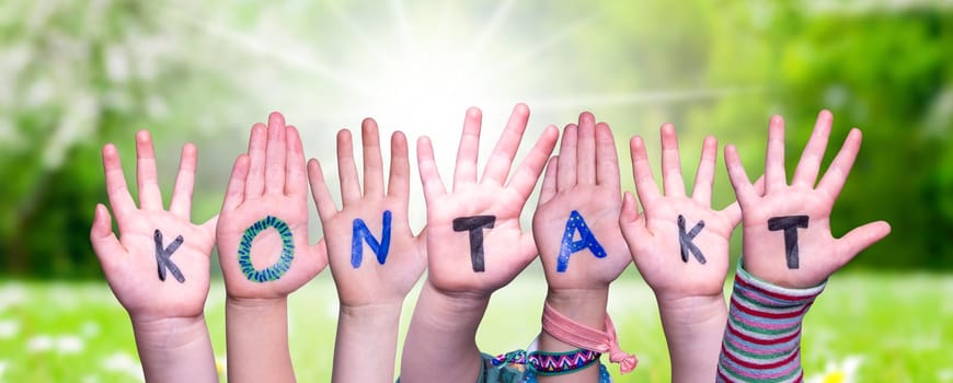 Children Hands Building Colorful German Word Kontakt Means Contact. Sunny Green Grass Meadow As Background.