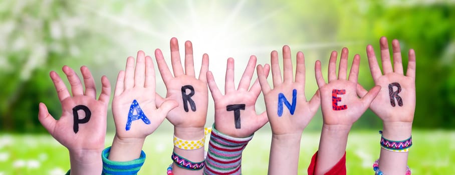 Children Hands Building Colorful English Word Partner. Summer, Sunny Green Grass Meadow As Background