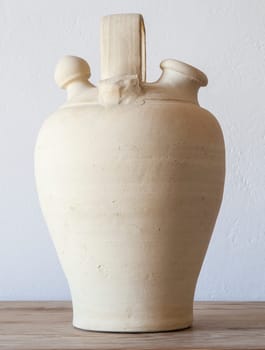 White earthenware botijo, traditional clay pot jug to keep fresh water. Selective focus