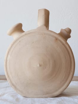 White earthenware botijo, traditional clay pot jug to keep fresh water. Circular shape