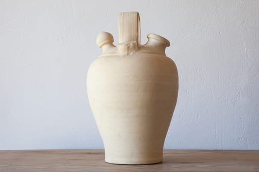 White earthenware botijo, traditional clay pot jug to keep fresh water. Selective focus