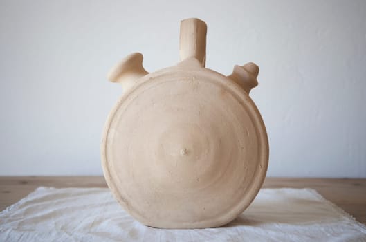 White earthenware botijo, traditional clay pot jug to keep fresh water. Circular shape