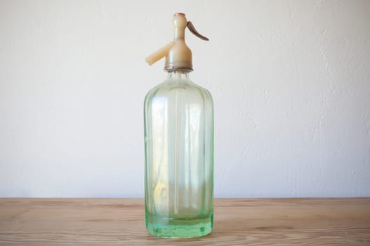 Old glass soda siphon. Wooden surface