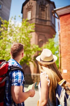 Modern tourists looking at old house during vacation