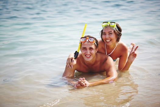Couple of happy scuba divers lying in water
