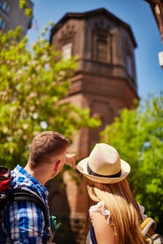 Traveling guy and girl looking at old house on vacation