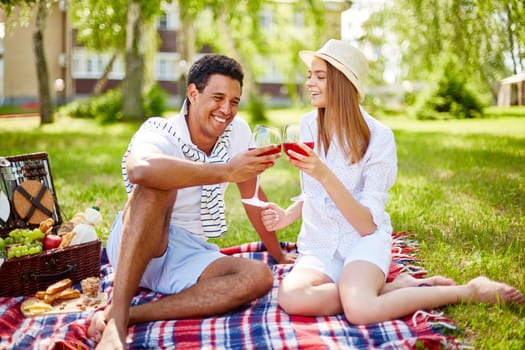Happy young couple having picnic in park