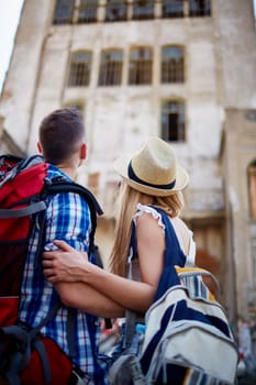Affectionate couple looking at old house during vacation