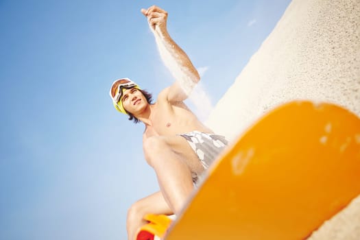Handsome sandboarder enjoying summer vacation