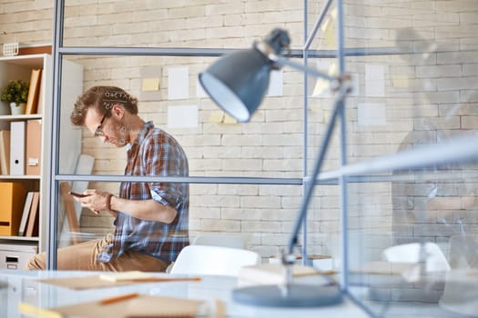 Modern businessman writing sms in office