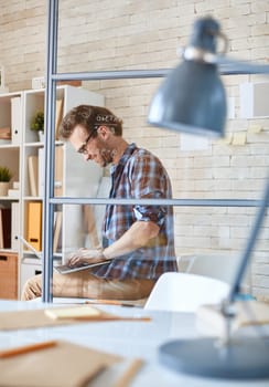 Happy young businessman typing in office