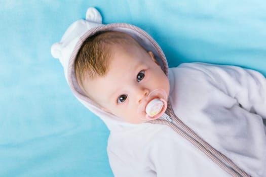 Cute baby in the hood on a blue blanket