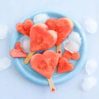 Cold watermelon in heart shape on a blue plate