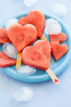 Cold watermelon in heart shape on a blue plate