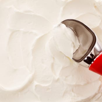 High Angle Close Up View of Red Handled Scoop Serving White Vanilla Ice Cream