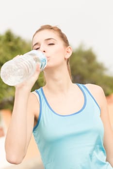 A young athlete takes a drinking break with mineral water