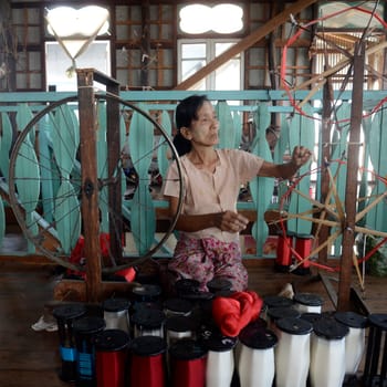 a women in a traditional weaving workshop Factory near the Village of Phaung Daw Oo at the Inle Lake in the Shan State in the east of Myanmar in Southeastasia.