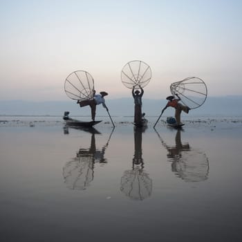 Fishermen at sunrise in the Landscape on the Inle Lake in the Shan State in the east of Myanmar in Southeastasia.