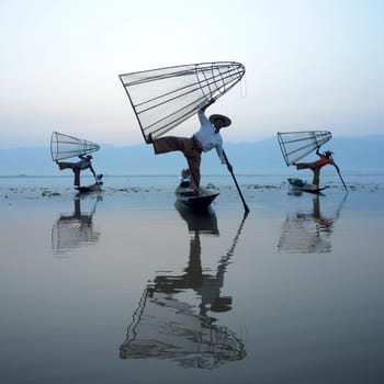 Fishermen at sunrise in the Landscape on the Inle Lake in the Shan State in the east of Myanmar in Southeastasia.