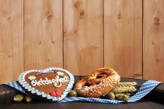 Bavarian Oktoberfest breze with gingerbread heart,hofen and wheat on old beer barrel