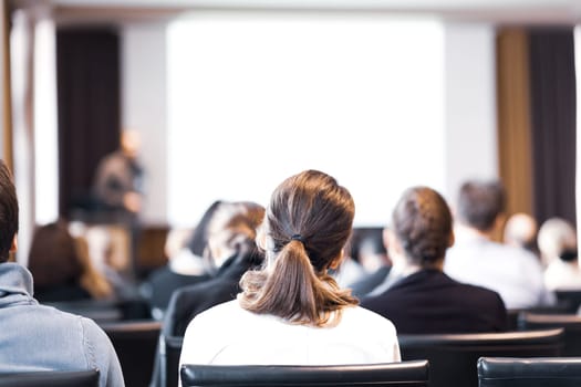 Speaker at Business Conference and Presentation. Audience in the conference hall. Business and Entrepreneurship. Copy space on white screen.