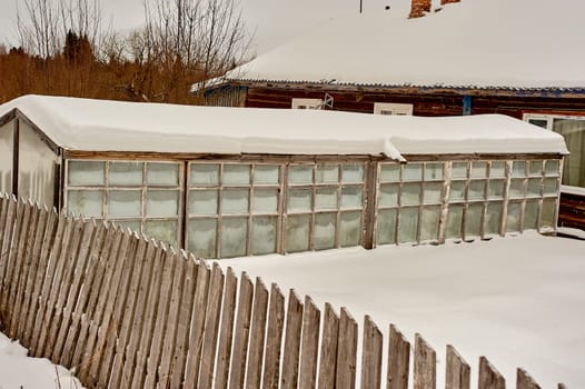 glass greenhouse covered with snow. High quality photo