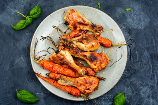 Appetizing chicken legs baked with vegetables. Homemade barbecue