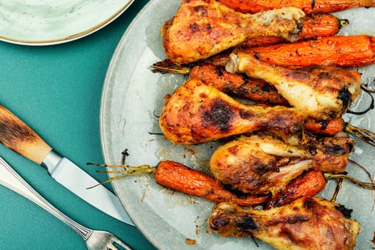 Appetizing chicken legs baked with vegetables. Homemade barbecue
