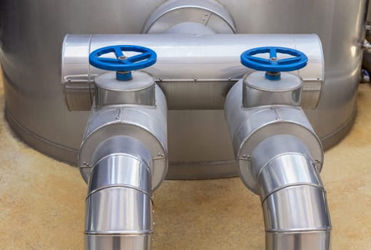Handwheel type blue metal valves and pipes, industrial equipment at wine factory, close up, copy space