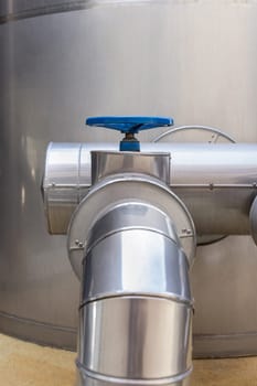 Handwheel type blue metal valve and pipes, industrial equipment at wine factory, close up, copy space