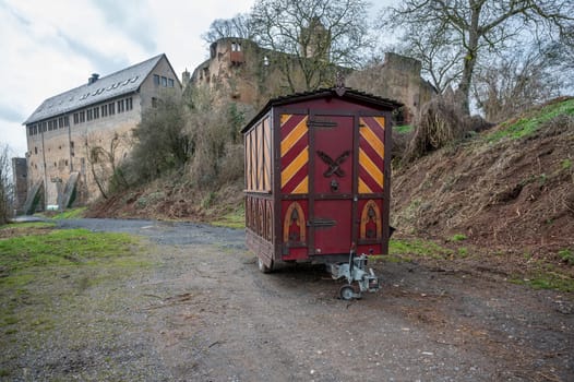 Decorative Trailer made of wood, Christmas market stand on a trailer in front of an old castle, Ronneburg Castle, Germany