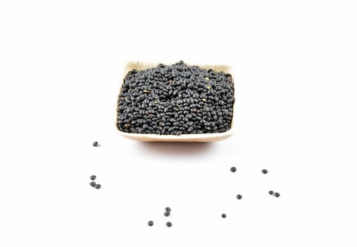 Beluga lentils in bamboo bowl on white background