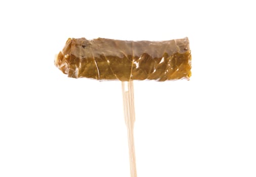 Stuffed vine leaves on wooden skewers on white background