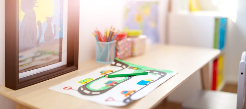 Closeup view of the child's drawing on the table in the children room. Colourful background.