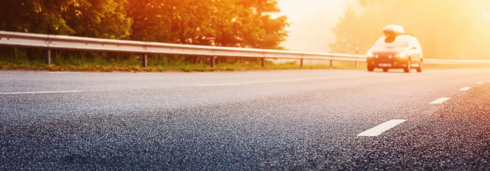 Car on the foggy road in the morning sunrise. Concept of the travel and transportation.