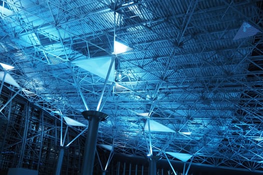 Metal structures under the ceiling. Decorative details of the airport ceiling . Concrete beams, glass windows and metal elements as public building interior design. Abstract avant-garde architecture