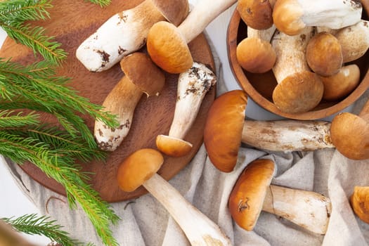 Brown boletus mushrooms on the background of a wooden tray. Top view.