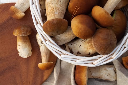 White wicker basket with boletus mushrooms. Top view.