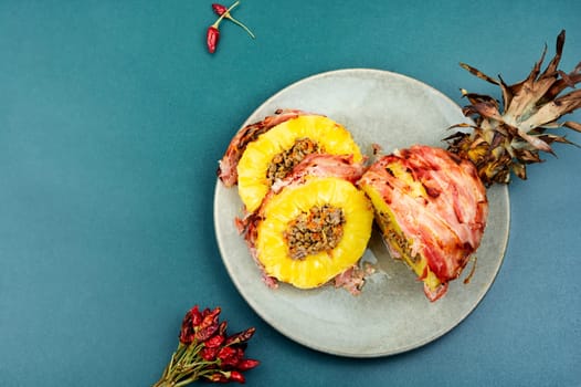 Delicious baked pineapple with spicy meat filling, wrapped bacon