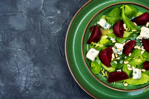 Salad with boiled beetroot, blue cheese, herbs and pine nuts. Diet detox raw food. Space for text