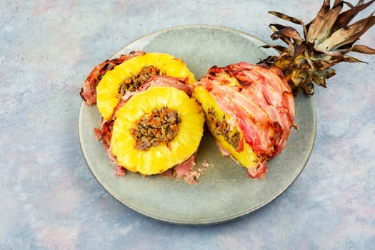 Delicious baked pineapple with spicy meat filling, wrapped bacon