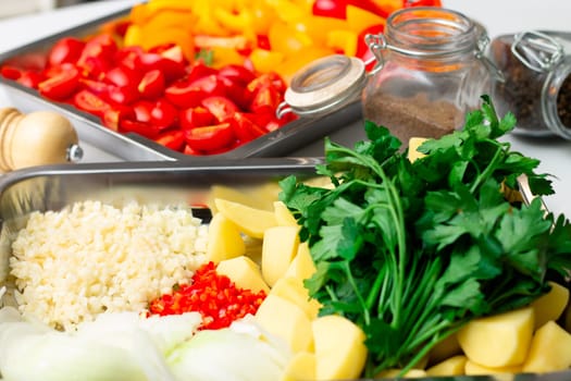 Chopped ingredients for making oriental vegetable stew. Paprika, potatoes, onions, tomatoes, garlic, peppers and spices.