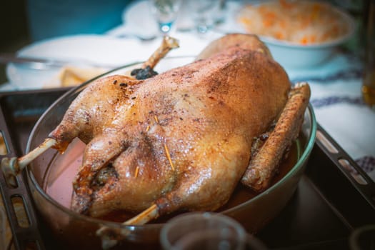Cooked baked goose or turkey on baking sheet, on table