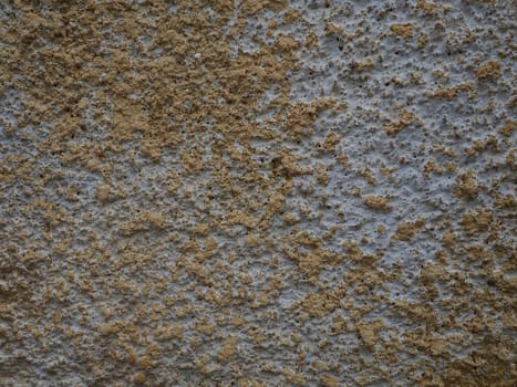 Concrete texture. Concrete wall with white and yellow paints. A casually painted wall. Grunge background with blank space. Copy space. Popcorn - plaster.