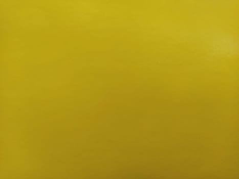 Nice yellow background. A sheet of paper close-up. Pure cheerful color. Vivid shade of yellow.