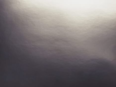 silver gray background with gradient. Light reflective colored paper with a metallic sheen. Background.