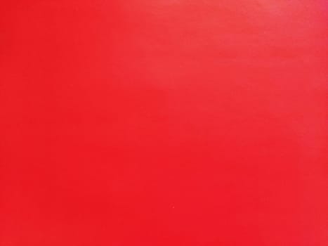 abstract red background or Christmas paper texture. Red base for cards for Valentine's Day, New Year, or Christmas. Color gradient.