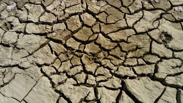 cracked clay soil due to drought and waste of river water. Red earth.