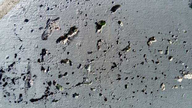 Concrete wall with concentric damage of large radius. Potholes, tubercles and defects. Grey colour. Planet surface concept. Concrete wall with a worn surface, potholes, bulges and small spots